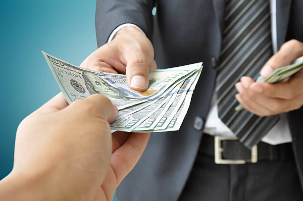 Hands giving & receiving money - United States Dollars (or USD) bills Hands giving & receiving money - United States Dollars (or USD) bills